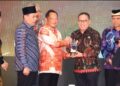 Makmur Marbun (kanan) saat menerima penghargaan dari Menteri Dalam Negeri, Muhammad Tito Karnavian. (foto : istimewa)
