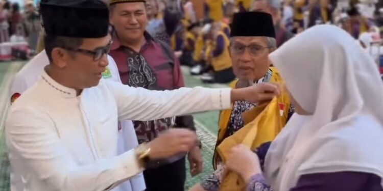 Wali Kota Balikpapan, Rahmad Mas’ud, secara simbolis melepas keberangkatan jemaah dengan mengenakan rompi kepada jemaah tertua dan termuda